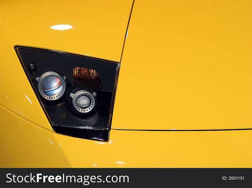 Yellow sportscar front reflector detail. Yellow sportscar front reflector detail