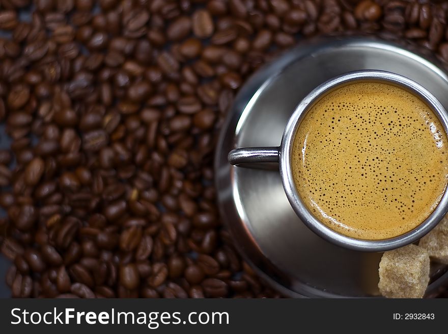 Cup of coffee in a pile of coffee beans