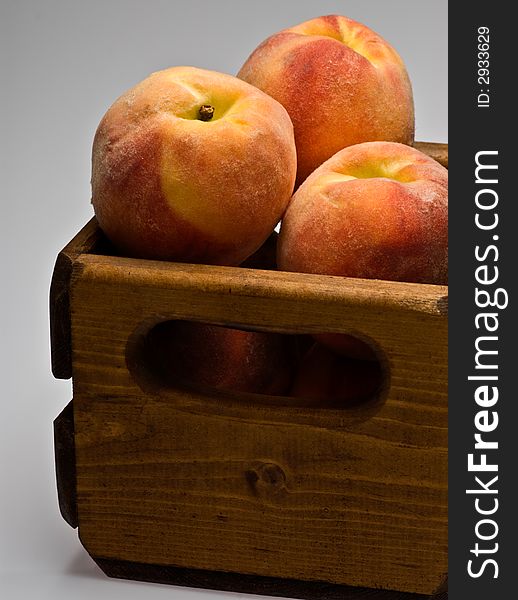 A close up shot of peaches stack in a wooden crate. A close up shot of peaches stack in a wooden crate