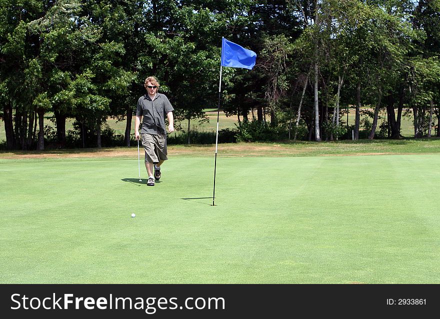 Man playing golf on the course. Man playing golf on the course.