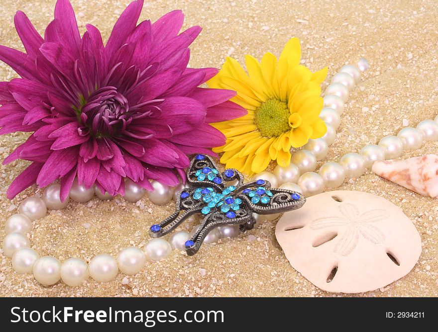 Flowers and Jewelry with Sea Shells on Sand