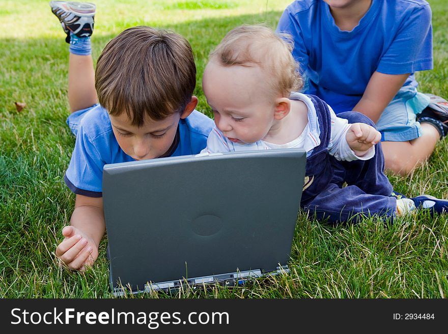 Three cute brothers study on computer