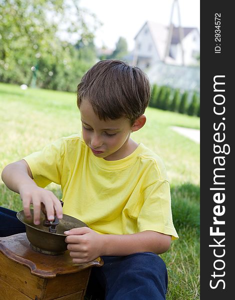 Boy and coffee mill on lawn