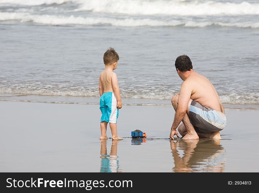 Father and son playing together on the beach