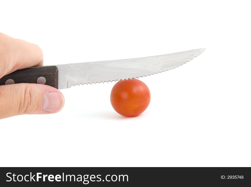 Photo of a knife in a hand cutting tomato