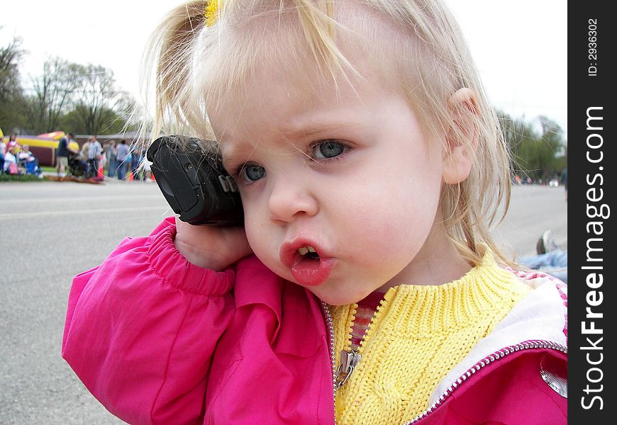 Little girl having a serious conversation on a cellular phone. Little girl having a serious conversation on a cellular phone.