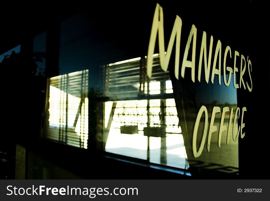 Manager's office sign painted on glass door.