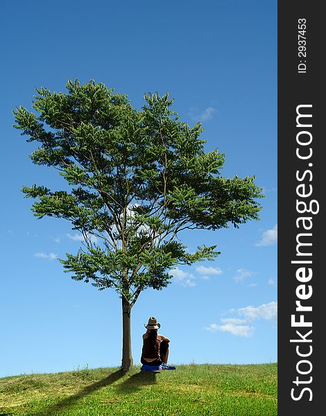 Single woman and tree on the medow.