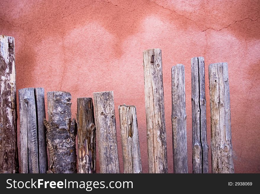 A bunch of small wooden posts form a small fence. A bunch of small wooden posts form a small fence