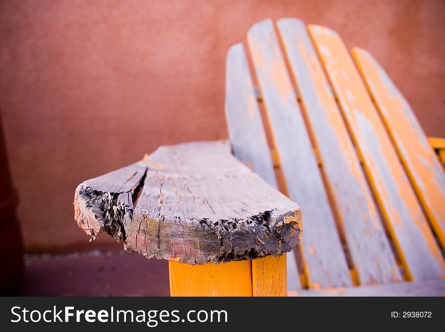 Shallow depth of field with focus on forefront armrest showing detail of broken wood with peeling paint. Shallow depth of field with focus on forefront armrest showing detail of broken wood with peeling paint