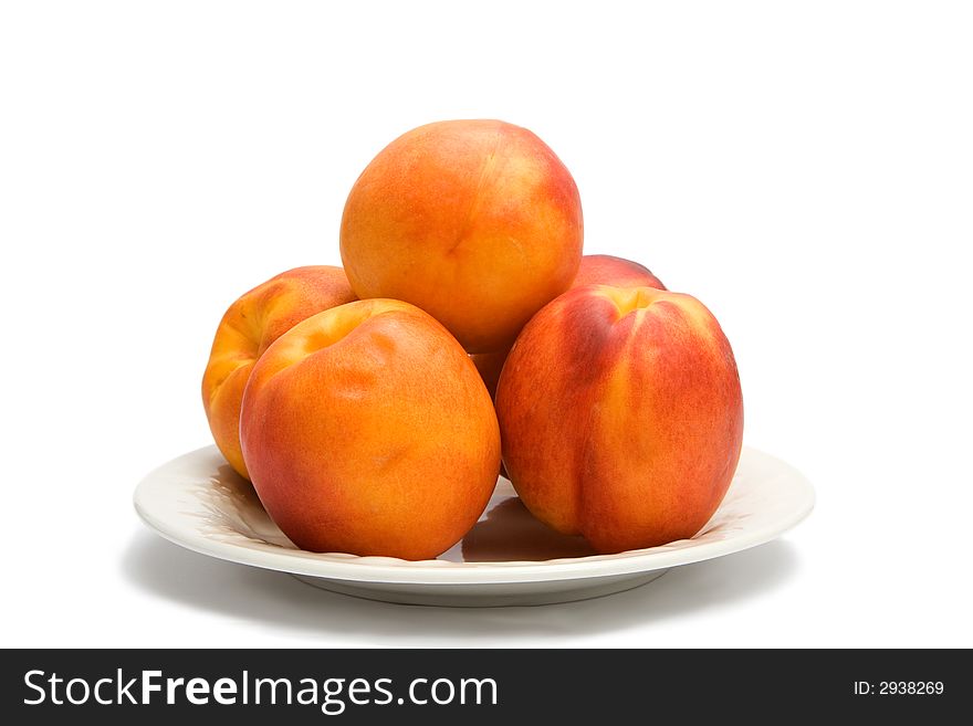 Five nectarines on a white plate isolated on a white background. Five nectarines on a white plate isolated on a white background.