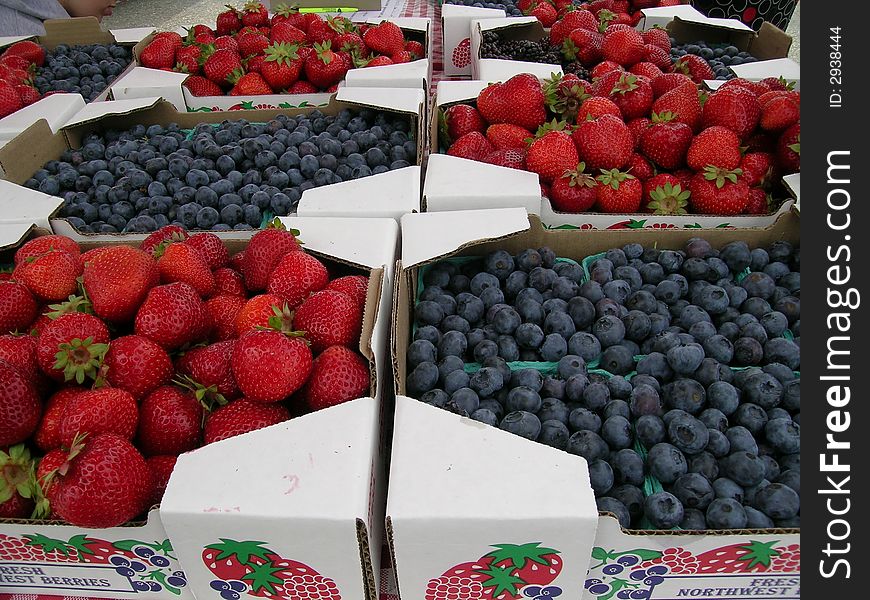 Strawberries and Blueberries on for sale at Farmers Market. Strawberries and Blueberries on for sale at Farmers Market