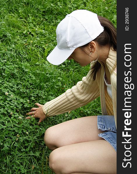 A pretty girl, searching for four-leaved clover. A pretty girl, searching for four-leaved clover