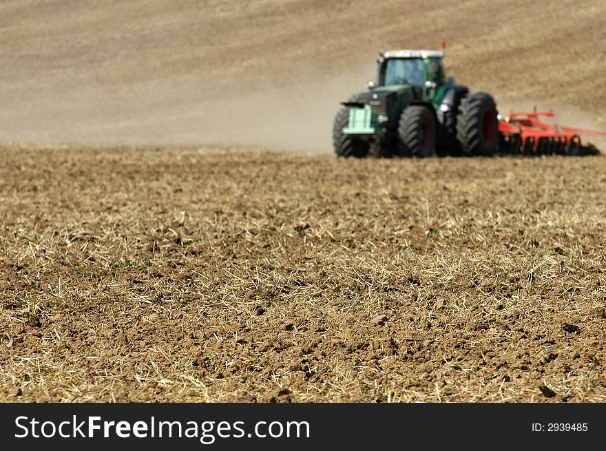 A tractor ploughing a field. A tractor ploughing a field