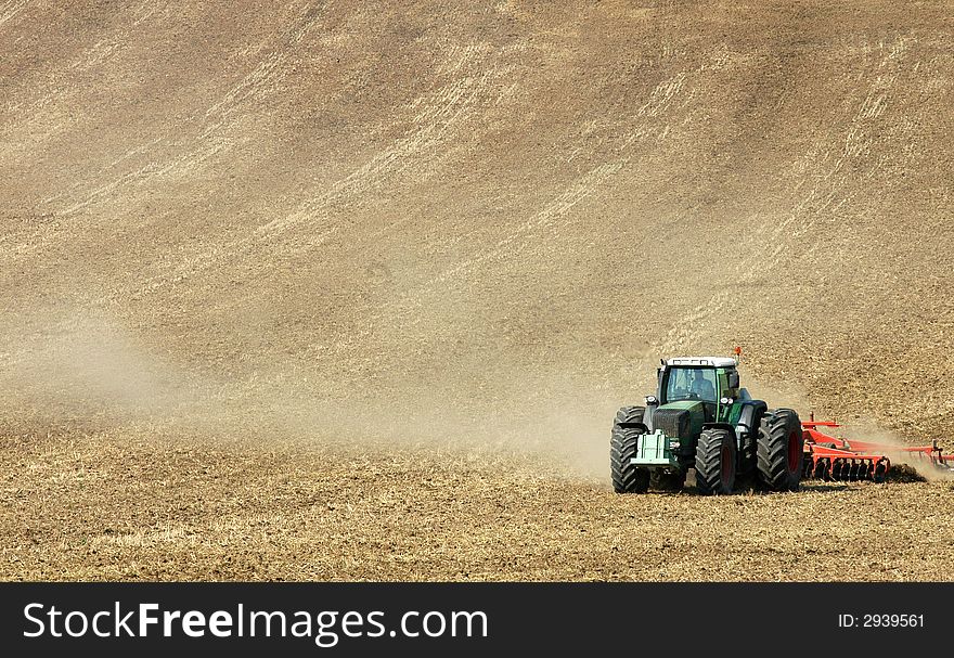 A tractor ploughing a field. A tractor ploughing a field