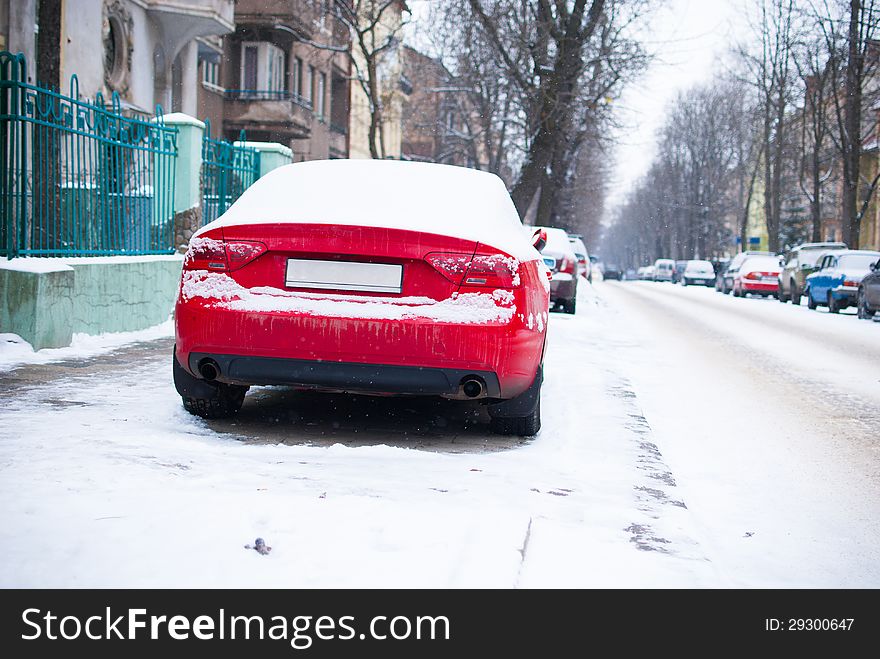 Red parked car near road in the city