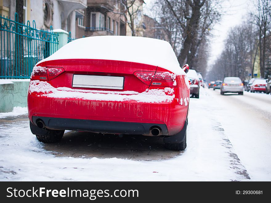 Red parked car near road in the city