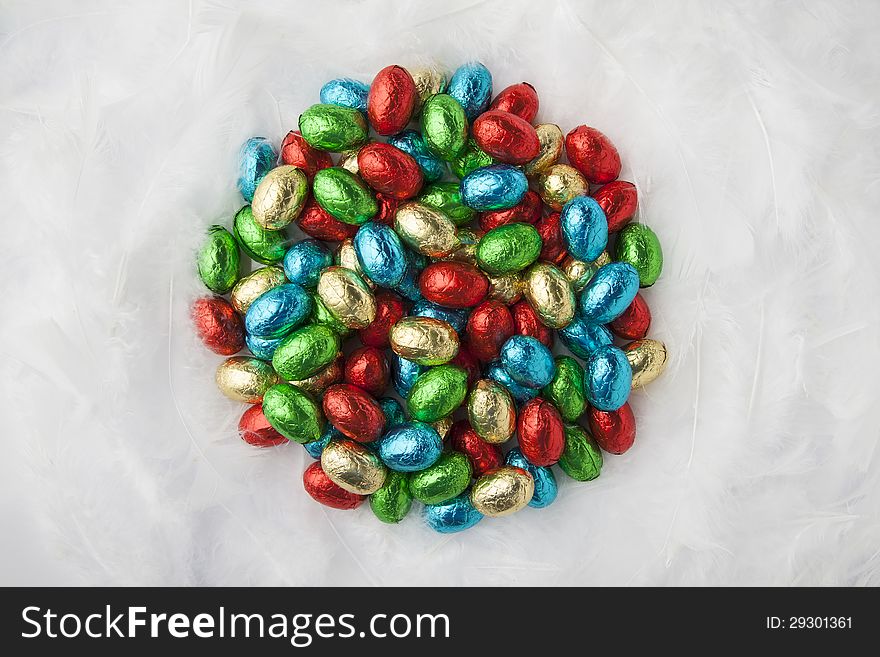 Chocolate easter eggs in colorful aluminium foil on down. Chocolate easter eggs in colorful aluminium foil on down