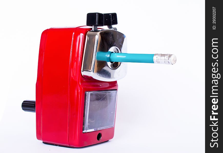 Red pencil sharpener with green pencil on white background