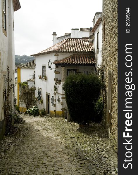 A cobblestone street in the medieval village of Obidos, Portugal. A cobblestone street in the medieval village of Obidos, Portugal.