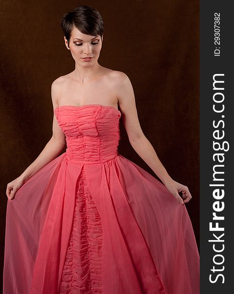 An image of a young woman in a pink strapless gown. An image of a young woman in a pink strapless gown