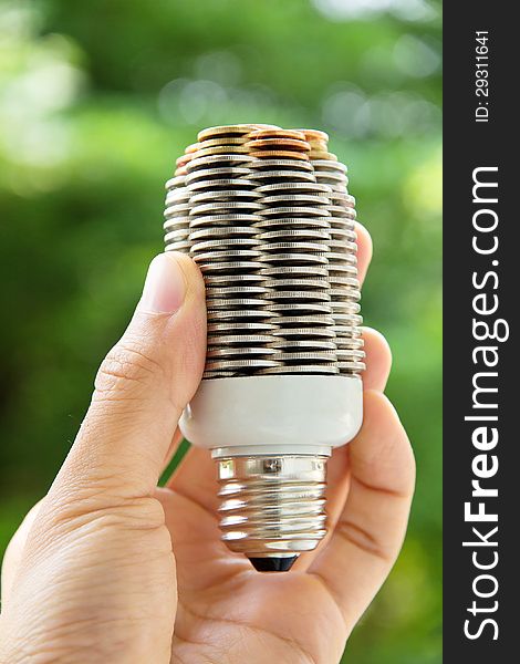 Hand holding coin light bulb,energy concept