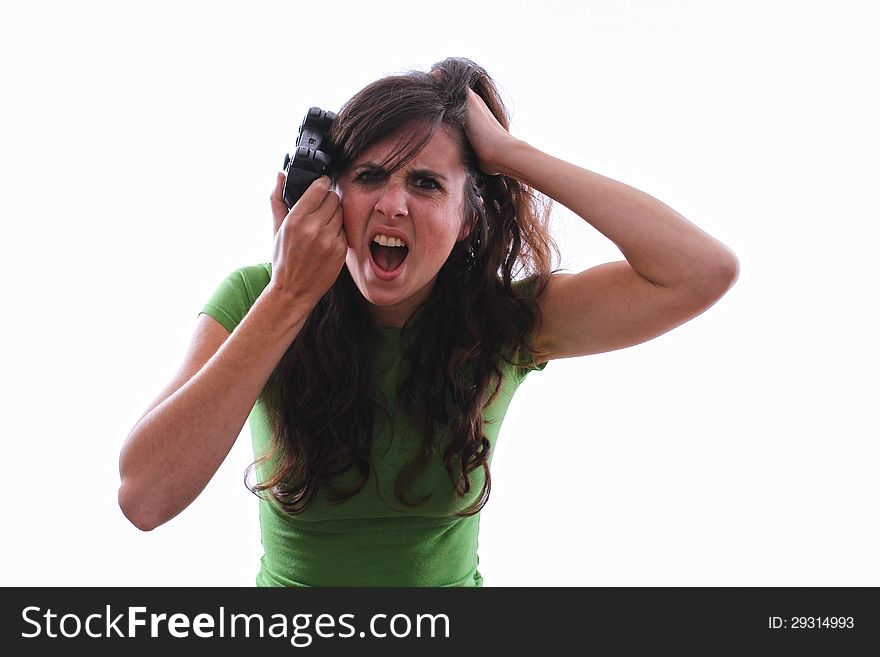 Caucasian female holding game controller against her head with her other hand in her hair screaming with anger at a console game. Caucasian female holding game controller against her head with her other hand in her hair screaming with anger at a console game.