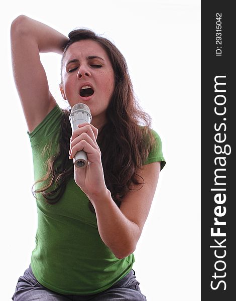 Caucasian female running her fingers through her hair singing a song through a microphone. Caucasian female running her fingers through her hair singing a song through a microphone
