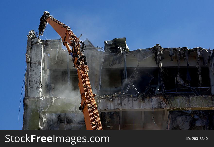 Crane equipped with a pneumatic drill destroying an old building. Crane equipped with a pneumatic drill destroying an old building.