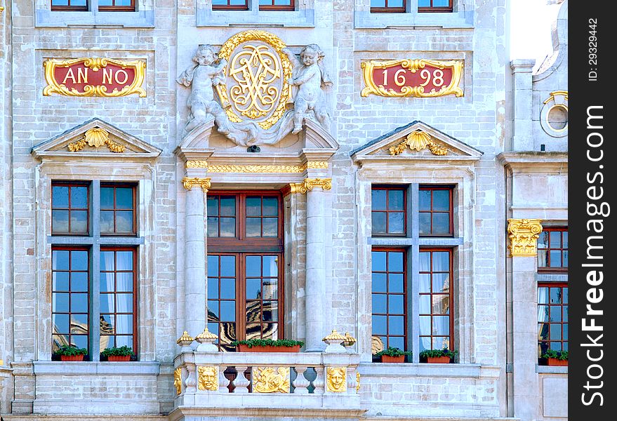 Grand Place In Brussels. Architectural detail at the Grand place statue on the wall. Large windows and a beautiful balcony. Belgium. Grand Place In Brussels. Architectural detail at the Grand place statue on the wall. Large windows and a beautiful balcony. Belgium.