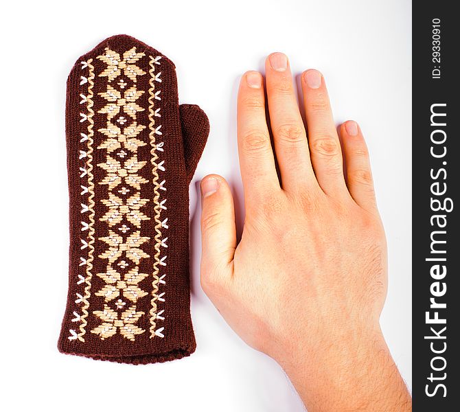 Brown woolen knitted mitten and hand on white background. Brown woolen knitted mitten and hand on white background