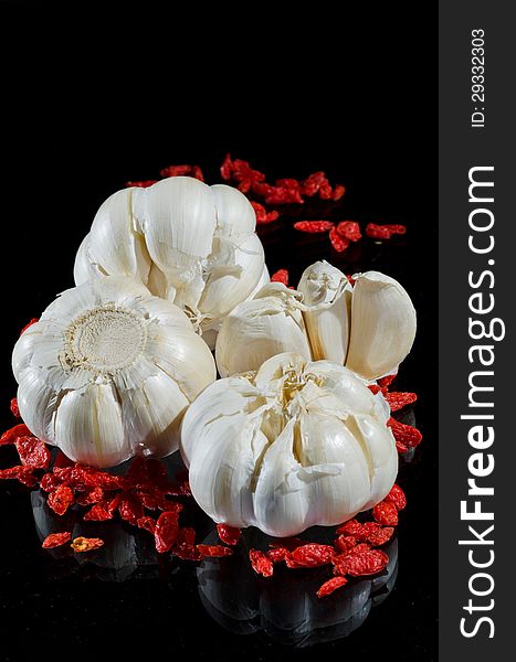 Garlic and wild rose seed on black background. Garlic and wild rose seed on black background