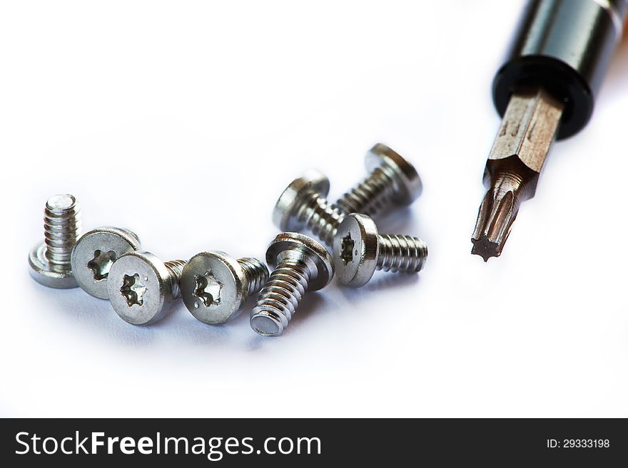 Screwdriver and screws on white background