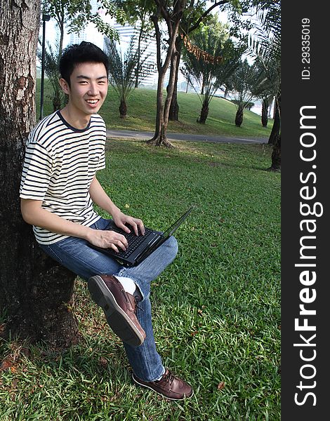 Young asian man working in the park