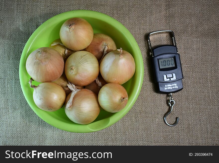Onions in a plate and electronic bezmen on a burlap.