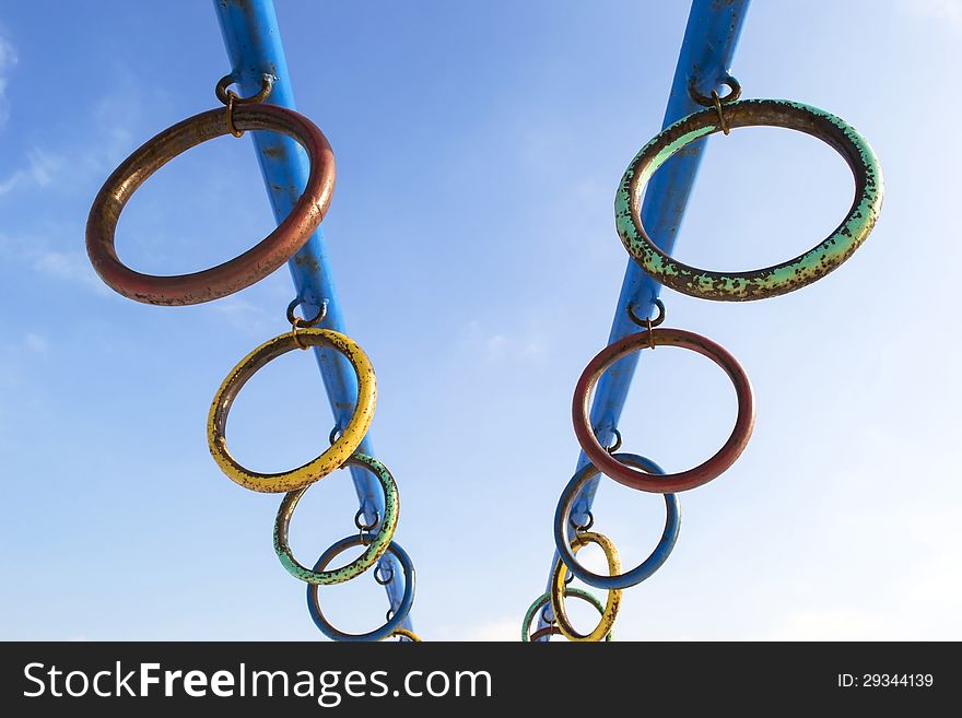 Rusty colored metallic rings over blue sky. Rusty colored metallic rings over blue sky