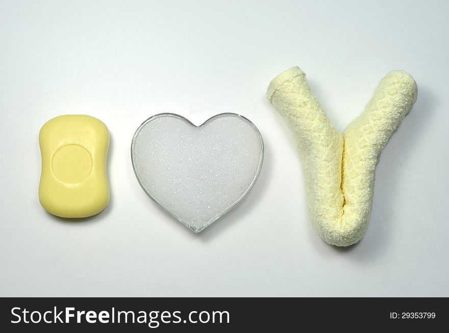 I love you written by a soap, a towel and a foam heart on white background