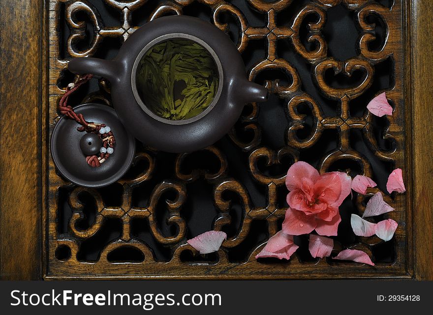 Green tea, falling flowers on carved woodwork. Green tea, falling flowers on carved woodwork