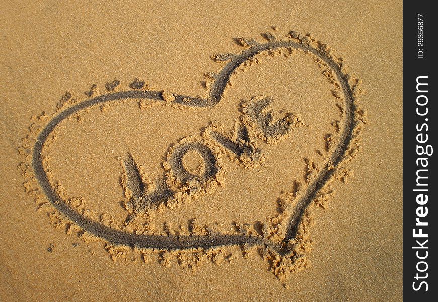 Heart drawn in the sand and the word Love. Heart drawn in the sand and the word Love