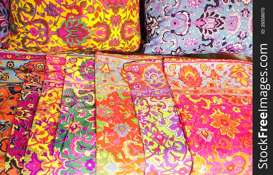 Piles of colorful pillowcase in a marketplace.