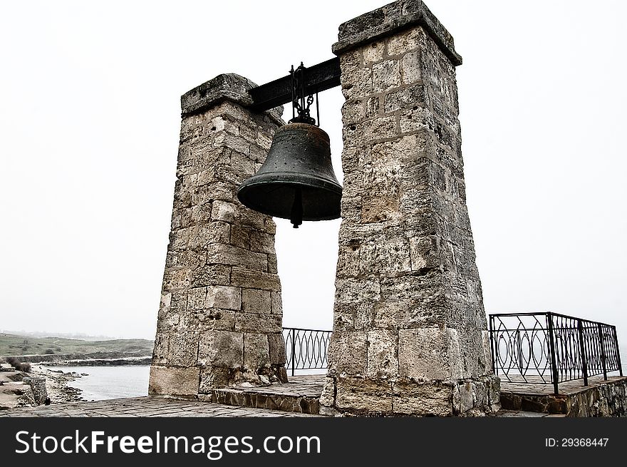 Old brass bell standing on the beach. Old brass bell standing on the beach