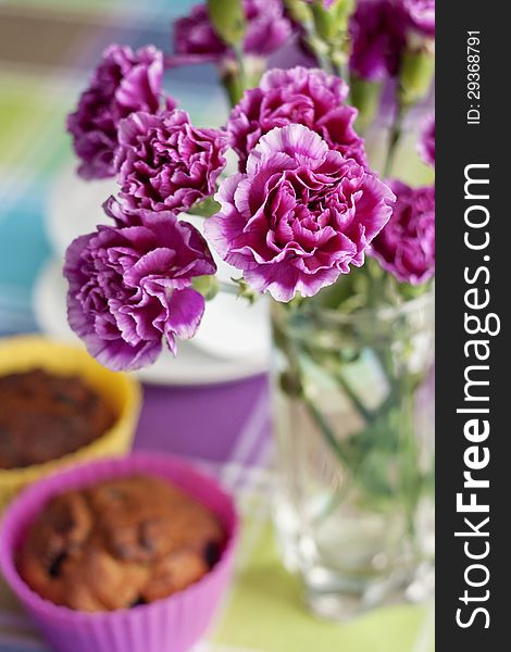 Purple Carnations And Maffins On The Table
