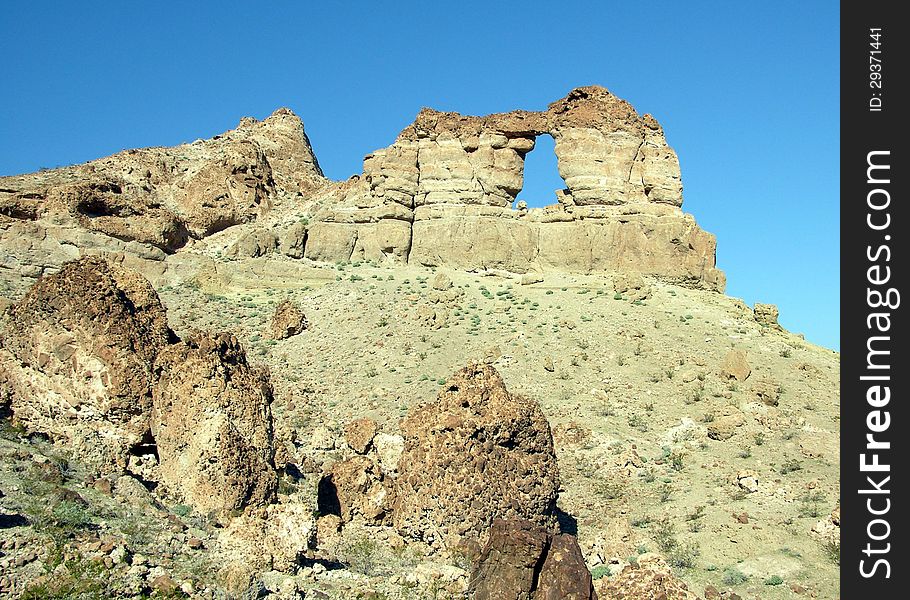 Liberty Bell Arch is an interesting geological rock formation on the Arizona side of the Colorado Rive near Hoover Dam. The opening in the rock has a shape similar to the famous Liberty Bell in Philadelphia, PA. Liberty Bell Arch is an interesting geological rock formation on the Arizona side of the Colorado Rive near Hoover Dam. The opening in the rock has a shape similar to the famous Liberty Bell in Philadelphia, PA.