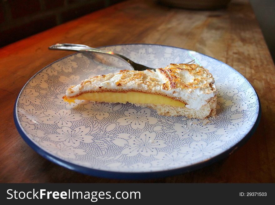 Delicious homemade lemon pie on colorful plate and long worn wood table. Delicious homemade lemon pie on colorful plate and long worn wood table.