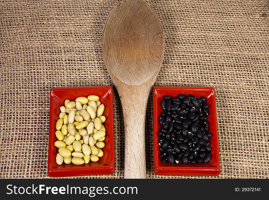 Mycoba beans and black beans in Japanese serving dishes on a textured bulap background. Mycoba beans and black beans in Japanese serving dishes on a textured bulap background.