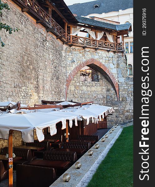 Image of rows of empty tables and chairs in  open air restaurant, located near the castle wall, Lviv, Ukraine. Image of rows of empty tables and chairs in  open air restaurant, located near the castle wall, Lviv, Ukraine