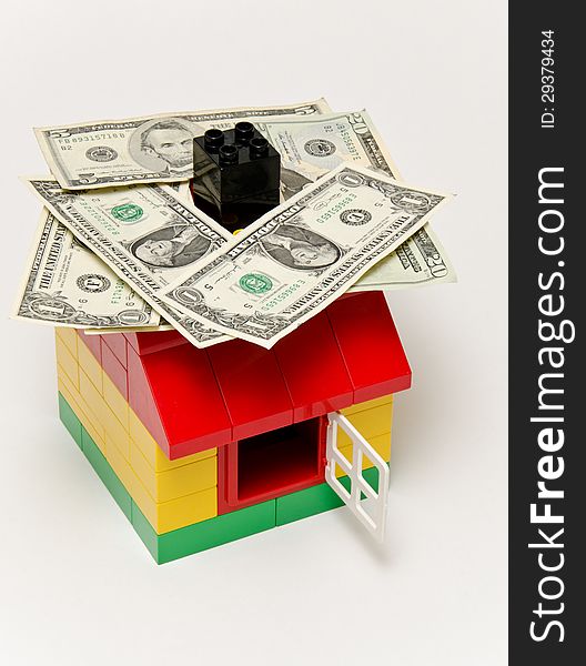 LEGO house and money. Dollars on the roof.