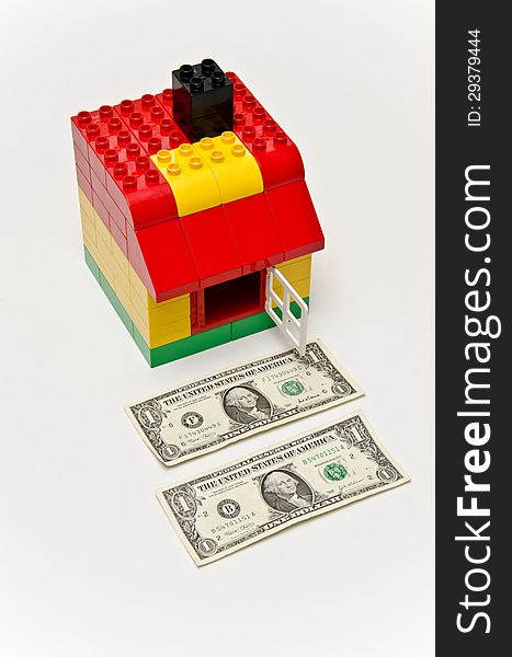 LEGO house and money. Dollars in front of the house.