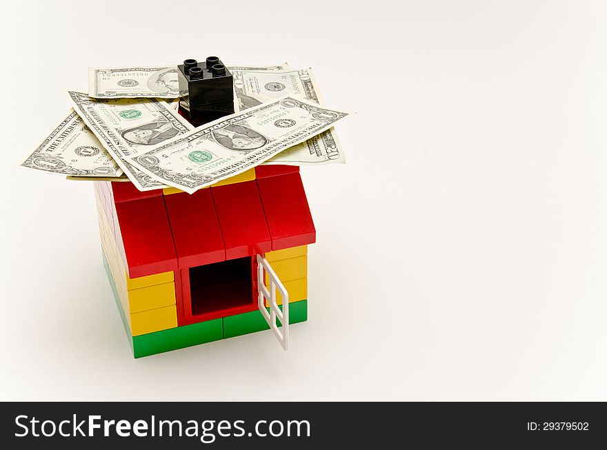 LEGO house and money. Dollars on the roof.