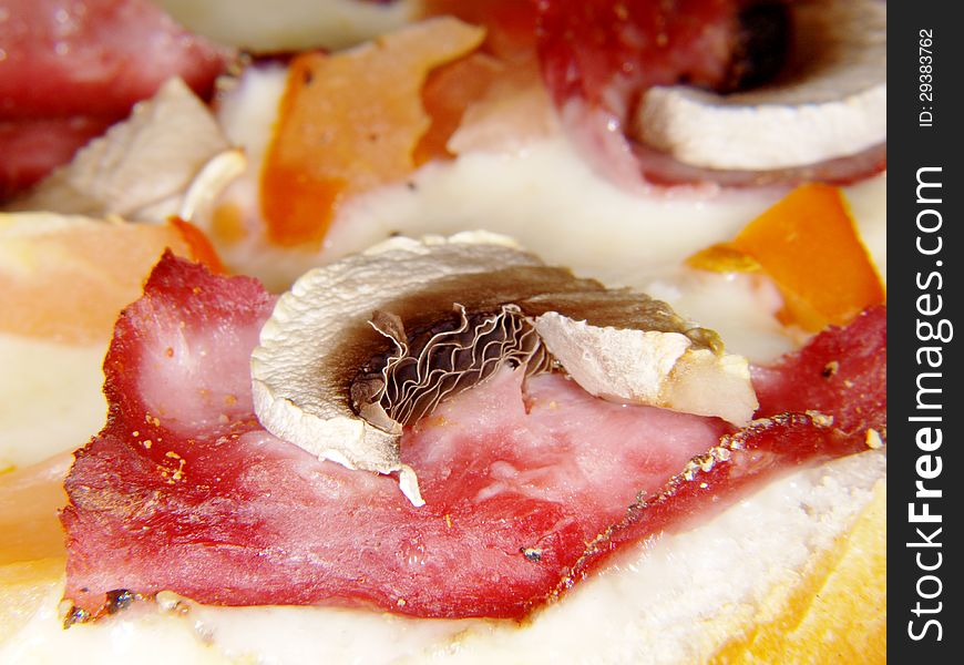 Sliced champignon on top of piece of ham and melted cheese. Sliced champignon on top of piece of ham and melted cheese